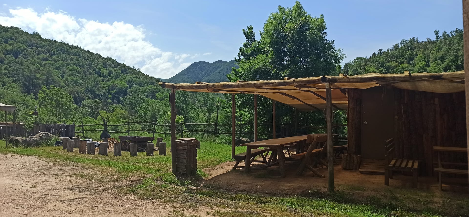 Outdoor space with a wooden porch and picnic tables at Castanya de Viladrau